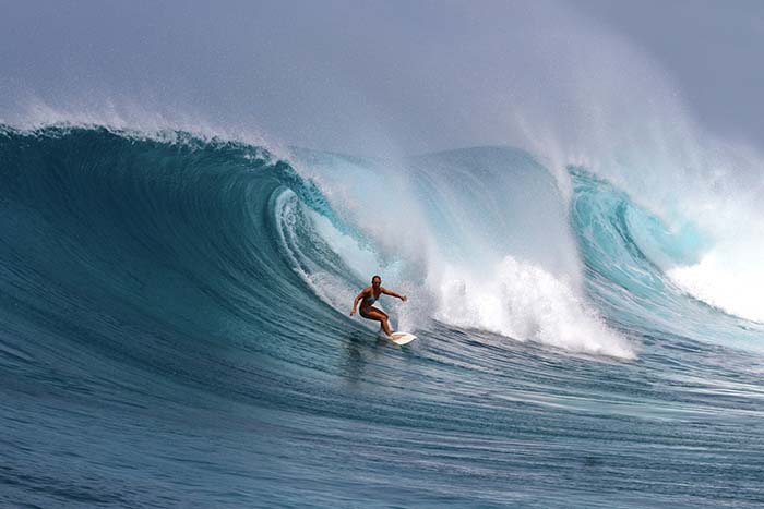 Female surfer riding a big powerful wave